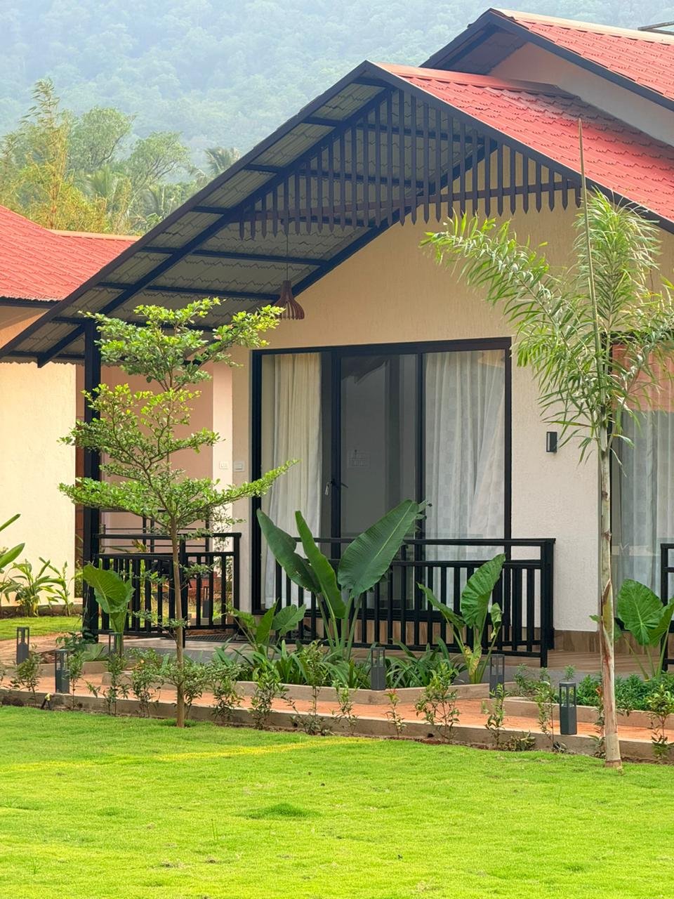 Premium AC cottage exterior at Nadi Teera Dandeli with mountain backdrop