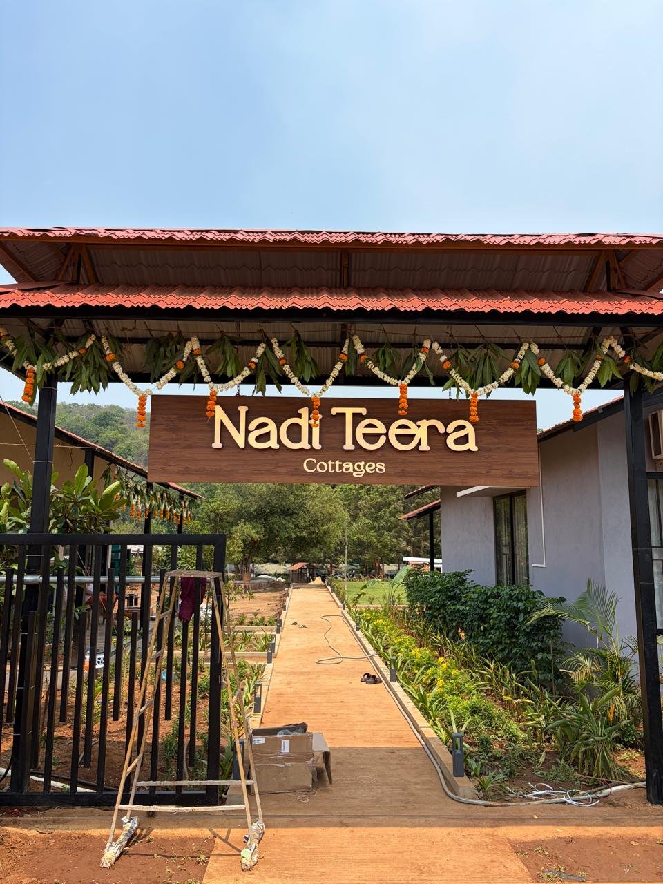 Nadi Teera Cottages welcoming entrance gate decorated with marigold garlands in Dandeli, Karnataka